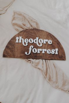 there is a sign that says hedge forest on the side of a bed with white sheets