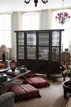 a living room filled with lots of furniture and decor on top of carpeted flooring