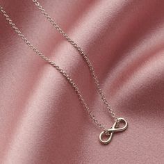 The dainty Sterling Silver Mini Infinity Charm Necklace is handcrafted from sterling silver in our Brighton workshop. The infinity symbol is seen to represent eternal love or everlasting friendship and makes a gorgeous gift for any occasion, perfect for birthdays, anniversaries, bridesmaid gifts or simply as a token of love and friendship. The Mini Infinity Charm Necklace features a delicate infinity pendant suspended from an extra fine chain, we love the contemporary look of the chain threaded Dainty Infinity Necklace As Gift For Her, Silver Infinity Necklace With Delicate Chain, Adjustable Sterling Silver Infinity Necklace, Minimalist Sterling Silver Infinity Necklace, Silver Infinity Dainty Necklace, Silver Dainty Infinity Necklace, Silver Infinity Necklace In Dainty Style, Dainty Silver Infinity Necklace, Delicate Infinity Silver Jewelry