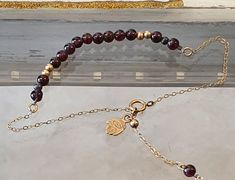 Garnet Bracelet- An Elegant and delicate  bracelet, made of high quality goldfield chain  with  round gold and 4 mm garnet bead balls ,  with goldfiled hamsa .The bracelet has the addition of a delicate dangling chain with a small garnet and gold bead at the end of the bracelet, adding to the beauty of the bracelet. The garnet stone is a stone in shades of red , it is solid and calm appearance, but beyond its appearance it gives strong and important powers to the person who wears it.  it strengt Adjustable Spiritual Garnet Jewelry, Adjustable Garnet Bracelets Gift, Adjustable Garnet Bracelet Gift, Adjustable Garnet Bracelet As Gift, Adjustable Garnet Gemstone Bracelets, Adjustable Garnet Gemstone Bracelet, Red Stone Bracelet, Garnet Bead Bracelet, Hamsa Bracelet