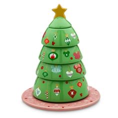 a green ceramic christmas tree sitting on top of a pink plate