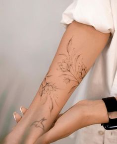 a woman's arm with a flower tattoo on it