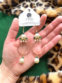 These gorgeous and unique statement hoops were designed in the art deco style of the 1920's. These are the perfect earrings for dressing up your holiday attire.These hoop earrings hang approximately 3.5" from the lobe and measure approximately 1.25" inches at their widest point. The design contains 12mm faux pearls, 4mm faux pearls, 3mm malachite heishi beads, and gold plated brass components.The leverback closure is 22k gold plated and should be suitable for sensitive ears. These are semi-light Brass Components, Holiday Attire, Heishi Beads, Art Deco Inspired, Hoop Art, Sensitive Ears, Art Deco Style, 22k Gold, Deco Style