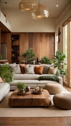 a living room filled with lots of furniture and plants on top of the couches