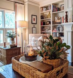 a living room filled with furniture and a fire place next to a book shelf on top of a hard wood floor