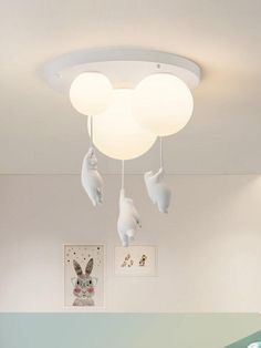 there is a bed and some lights in the room with animals hanging from the ceiling