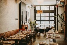 an empty restaurant with tables and chairs set up for dinner or other meal, in front of a large window