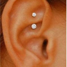 a woman's ear is shown with two small stars on it