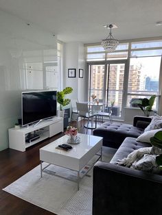 a living room filled with furniture and a flat screen tv on top of a wooden floor