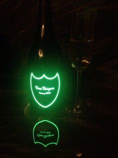 two green and black lights in the shape of fish on a dark surface with one glowing