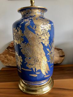 a blue and gold vase sitting on top of a wooden table