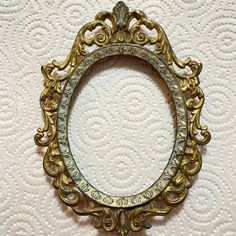 an ornate gold framed mirror on a white wall