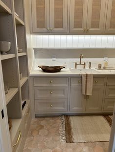 a kitchen with white cabinets and beige tile flooring