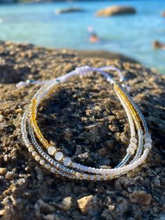 Hard-wearing, multi-strand Japanese seed bead anklet with white waterproof cord with gold, silver and white sparkling beads.  Fully adjustable (22-30cm) with slip-knot. 🌊 🏊✅ Pool & ocean proof.  📦✅ Shipped FREE in the UK and dispatched on the SAME DAY where possible. 🎁✅ Gift wrap option available.  Visit our Etsy site to view other Ben's Beach jewellery --> https://www.etsy.com/uk/shop/BensBeach 🌐 Visit our main site --> https://bensbeach.com/ to view our wider selection and subscribe for u Gold Beaded Bracelets With Sliding Knot For Summer, Resizable Gold Beaded Bracelets For The Beach, Gold Friendship Bracelets With Gold Beads For Beach, Gold Strand Beaded Bracelets For Summer, Gold Beaded Anklets For Beach, Gold Friendship Bracelets With Colorful Beads For The Beach, Adjustable Gold Beads Friendship Bracelet For Beach, Gold Anklets With Tiny Beads For Beach, Adjustable White Anklets With Colorful Beads