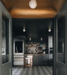 an open door leading to a kitchen with tiled floors