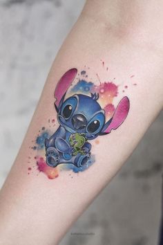 a watercolor tattoo of a stitching stitcher holding a frog in it's right arm