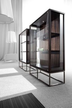 three glass shelves in the middle of a room with white walls and carpeted flooring