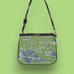 This unique and vibrant shoulder bag adds a chic touch to any outfit. Its compact size (10"w x 8"h) and lightweight construction makes it the perfect accessory for carrying around your essentials in style. A beautiful Cheng toile print in navy and green is printed onto high-grade vegan leather by our top-rated production partner, made to order just for you. .: 100% high-grade vegan leather .: Polyester lining + 20-inch black strap .: Two open pockets inside .: Gold-colored zipper and hardware .: Unique design only available here! Care instructions: avoid prolonged exposure to sunlight to ensure long lasting color rendering; store in a dry place; do not dry clean. Before cleaning the bag, remove all the items from the bag. Gently wipe surface with a soft cloth using mixture of mild laundry Vintage Canvas Shoulder Bag For Summer, Vintage Coated Canvas Shoulder Bag With Removable Pouch, Vintage Shoulder Bag With Removable Pouch In Coated Canvas, Vintage Coated Canvas Shoulder Bag For Evening, Green Coated Canvas Shoulder Bag For On-the-go, Vintage Blue Canvas Shoulder Bag, Green Coated Canvas On-the-go Shoulder Bag, Summer Coated Canvas Shoulder Bag For Daily Use, Rectangular Canvas Evening Bag