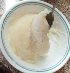 a bowl filled with ice cream sitting on top of a counter next to a spoon