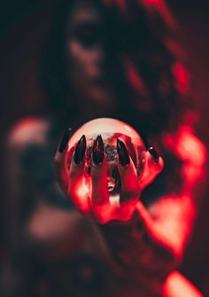 the reflection of a woman's face in a glass ball with red lights on it