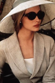 a woman wearing a white hat and sunglasses