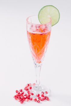 a glass filled with liquid and garnished with pomegranate