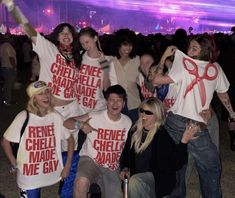 a group of people standing next to each other holding up t - shirts with words on them