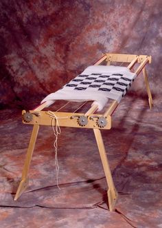 a wooden table with a white and black cloth on it's legs, sitting in front of a brown background