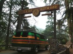 a van driving under a sign that reads camp redwood