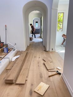 a hallway with hard wood flooring and tools on the ground in front of it