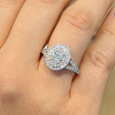 a woman's hand with a diamond ring on top of her finger and an engagement band