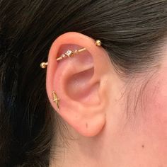 a close up of a person's ear with two piercings on top of it