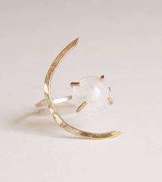 This beautiful white moonstone gemstone features a subtle glow. Set in 14k gold fill, this ring is a perfect for everyday wear or as a statement piece. Featuring a stunning crescent moon shape design. Ring is made in size 6 and is adjustable due to the style of the ring. It can be made larger upon request before purchase. Gemstone is approx. 10mm in diameter. This piece is a very limited edition. Please note: Due to the nature of the moonstones, each of these stones can vary from the original. M Adjustable Ethereal Moonstone Ring, Ethereal Adjustable Moonstone Ring, Moonstone Crystal Ring With Moon Phase, White Moonstone Crystal Ring In Celestial Style, Celestial Moon Shaped Moonstone Crystal Ring, White Moonstone Moon Ring, White Adjustable Celestial Moonstone Ring, Celestial Moon-shaped Moonstone Crystal Ring, Celestial White Moonstone Crystal Ring