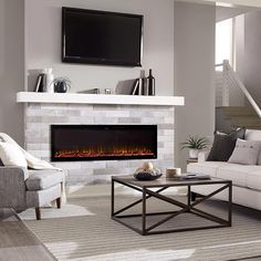 a living room with white furniture and a fireplace