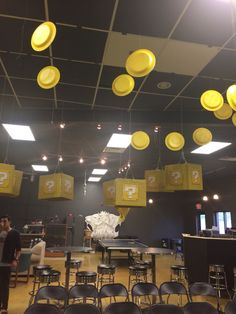 a large room filled with lots of chairs and yellow lights hanging from the ceiling above