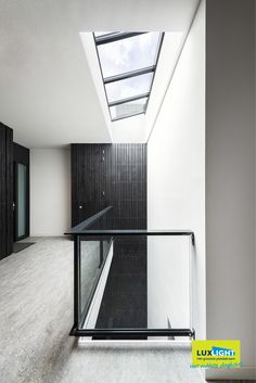 an empty room with glass railings and skylights