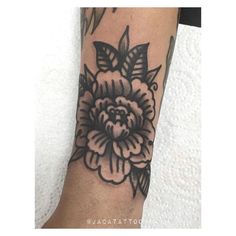 a black and white flower tattoo on the arm