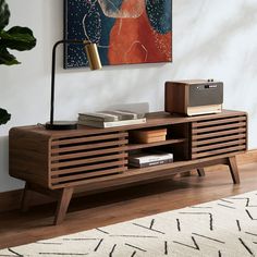 a living room with a wooden entertainment center on top of a hard wood floor next to a painting