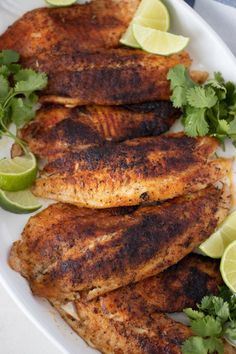 grilled chicken with cilantro and limes on a white serving platter