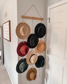 several hats are hanging on the wall in front of a door with a sign that says,