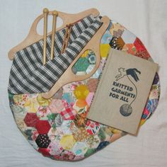 an assortment of crafting items on a plate with a book and knitting needles in it