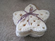 two crocheted star ornaments tied together on the floor