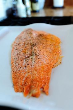 a piece of cooked fish sitting on top of a white plate