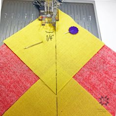 a yellow and red piece of fabric being sewn on to a machine with sewing needles