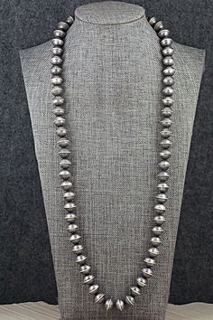 This sterling silver Navajo Pearl necklace was made by Navajo silversmith Gilbert Martin. The cone is stamped sterling.Necklace: 26"Bead size: 3/8" x 7/16" (9mm x 11mm)Free shipping on all orders! We ship with USPS and always include tracking. All orders ship within a day of payment.Returns are accepted up to 30 days a Western Style Engraved Silver Necklace, Western Style Silver Engraved Necklace, Western Silver Engraved Necklaces, Navajo Pearls Necklace Outfit, Southwestern Sterling Silver Concho Necklace, Silver Southwestern Concho Necklace, Southwestern Silver Concho Necklace, Navajo Pearls And Turquoise Necklace, Navajo Pearls Necklace