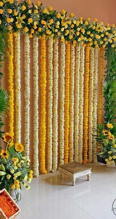 an arrangement of yellow flowers and greenery on the side of a wall in a room