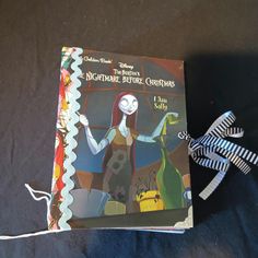 an image of a book with a ribbon attached to it on a bed sheeted surface