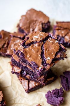 some brownies are stacked on top of each other and have purple frosting in them