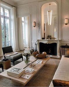 a living room filled with furniture and a fire place in front of a window next to a fireplace