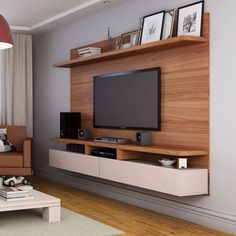 a living room with furniture and a flat screen tv mounted on the wall above it